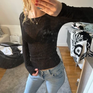Svart tight långärmad topp - Intimissimi doup. Säljer en svart, tight och långärmad topp i tunn och lätt genomskinlig kvalitet. Modellen är figurnära med rund halsringning och stretchigt material som sitter snyggt mot kroppen. Perfekt att styla med jeans eller kjol för en clean look.
