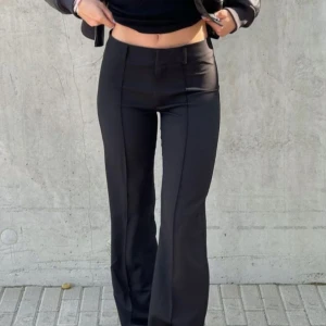 Svarta kostymbyxor - Snygga svarta kostymbyxor med bootcut-snitt och medelhög midja som går att fälla ner om man gillar en känsla av en lägre byxmidja🩶 Byxorna har pressveck framtill och bälteshällor, vilket ger en clean och trendig look som passar perfekt till alla outfits. Personligen mina favorit byxor som jag köper om varje gång, tyvärr säljer jag dessa nu i storlek 40 pga att de blivit för stora för mig! Hör av er vid frågor eller om ni vill ha mer bilder 🩶
