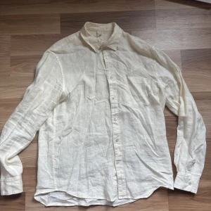 Off-White  linneskjorta Arket - Snygg off white skjorta i linne med klassisk krage och bröstficka från Arket Regular fit för en avslappnad men stilren look. Perfekt till jeans eller chinos. Långärmad och med knappar framtill. Enkel och fräsch färg som passar till mycket.