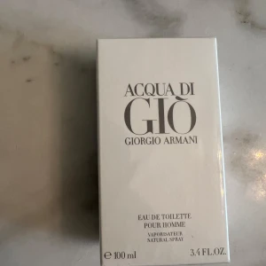Acqua di Giò pour Homme 100ml - Fräsch och ikonisk herrparfym från Giorgio Armani, Acqua di Giò pour Homme. Eau de toilette i 100 ml förpackning. Kommer i en stilren, vit kartong med silverfärgad text. Perfekt för dig som gillar klassiska och fräscha dofter.