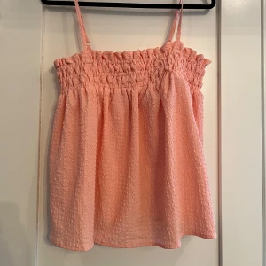 Somrig topp - Så fin somrig topp i en rosa/orange färg. Perfekt nu till sommaren. Storlek M men passar även S