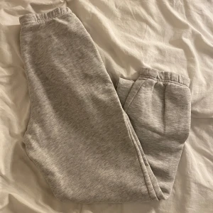 Grå mjukisbyxor från Gina Tricot  - Supermysiga ljusgrå mjukisbyxor från Gina Tricot i storlek XS. De har resår i midjan och vid bensluten samt praktiska sidofickor. Perfekta för chill dagar eller när du vill vara extra bekväm. Materialet är mjukt och skönt bomullsmix.