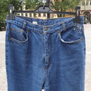 Stjärnbroderade Jeans  - 💙🌟Blå jeans handbroderade av mig! Vänster framficka och höger bakficka har mycket fina stjärnor broderade på sig. Jeansen är i väldigt bra skick, men vänster ben är stilfullt lagat med lappar. De är storlek 42 och passar både dem som brukar ha M och L.  📍Om du bor i Uppsala erbjuder jag upphämtning (alltså ingen frakt!), skriv till mig så berättar jag mer.  🧺Går att maskintvätta men var lite försiktig!