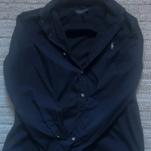 Ralph lauren skjorta -  Hej jag säljer min riktigt snygga skjorta från Ralph lauren med jätte bra skick i storlek M men passar även S. Perfekt nu för sommarn. Den är mörkblå så den passar till nästan vad som helst. Om ni har några funderingar kan ni bara skriva så svarar jag så fort som de går! 👍