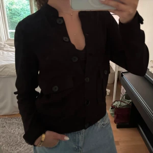 Svart tunn jacka med knappar - Snygg svart tunn jacka med fickor och knappar framtill