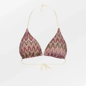 Beck Söndergaard Mönstrad bikinitopp - Säljer en trekantsbikini med knyt i nacken och ryggen från Beck Söndergaard. Den är helt oanvänd och har kvar alla lappar. Jag hade tänkt att returnera och byta storlek då den inte passade mig men då hade returtiden redan gått ut. Därav säljer jag den här. Bikinin har ett mönster i rosa och beige. Perfekt för stranden eller poolen!💕