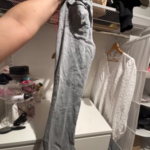 Grå bootcut jeans - Säljer ett par ljusgrå jeans med bootcut passform. Klassisk femficksmodell och normalhög midja. Perfekta för dig som gillar en avslappnad men ändå trendig stil. Passar till det mesta och är lätta att matcha.