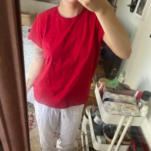 Röd t-shirt från Cubus i st M - En klassisk röd t-shirt med rund halsringning och korta ärmar. Modellen har en normal passform och är enkel att matcha till olika outfits. Perfekt för dig som gillar en basic och stilren look. 