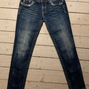 Miss Me skinny jeans med broderade fickor - Säljer ett par blå skinny jeans från Miss Me med broderade och dekorerade bakfickor. Jeansen har låg midja, snygga slitningar och detaljerade sömmar. Perfekta för dig som vill sticka ut med coola detaljer och unik stil! ❤️🔥