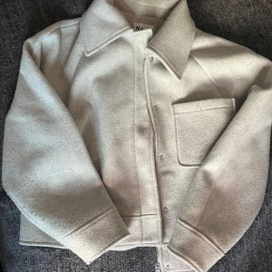 Ljusgrå kappa från NA-KD - Säljer en ljusgrå overshirt med klassisk krage och stor bröstficka. Mysig till höst/vår🥰