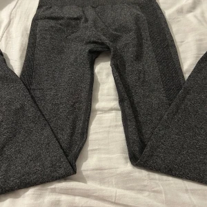 Mörkgrå träningstights från Energetics - Mörkgrå träningstights från Energetics i stretchigt material. Tightsen har en tight passform och är perfekta för träning eller sport. De är helfärgade utan synliga mönster och har en bekväm midja.