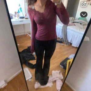 Vinröd intimissimi - Säljer en vinröd långärmad topp med v-ringning och fina spetsdetaljer längs halsringningen. Toppen är figurnära och passar perfekt till både jeans och kjol. Superfin färg och mjukt material.