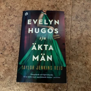 Evelyn Hugos sju äkta män - En gripande roman om Hollywoodstjärnan Evelyn Hugo och hennes sju äktenskap. Boken har ett omslag med en kvinna i en grön klänning och guldiga bokstäver. Perfekt för dig som gillar drama och starka karaktärer.