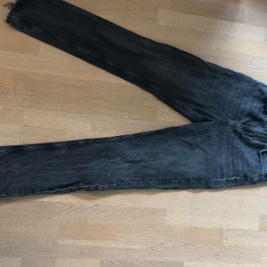 Gråa jeans från Gina tricot  - Säljer ett par grå jeansbyxor från gina tricot i en klassisk femficksmodell. Byxorna har raka ben och normal passform, med tydliga sömmar och silverfärgade knappar. Ser mörkare ut på långdistansbild, är en mer realistisk färg på närbildena.