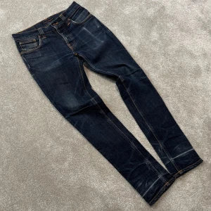 Nudie Grim Tim - Tja! Säljer nu dessa riktigt snygga mörkblå Nudie ”Grim Tim” jeans med fet tvätt! Jeansen är i prima skick! Size 30/32. Skriv vid funderingar!