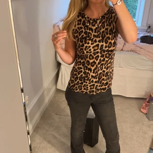 Leopardmönstrat linne - Snyggt leopard linne som är superskönt på sommaren. Sitter fint på och är stretchig så passar en storlek större. Endast använt en gång, säljer då den inte kom till användning tyvärr.