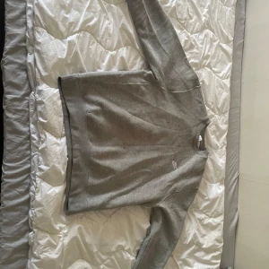 Grå sweatshirt från Carhartt - Säljer en stilren grå sweatshirt från Carhartt. Tröjan har rund halsringning och långa ärmar. Perfekt för en avslappnad och enkel look. Liten logga på bröstet.