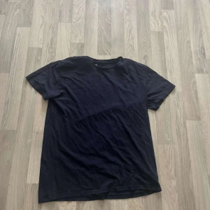 Svart basic t-shirt i bomull - Enkel svart t-shirt i klassisk modell med rund hals och korta ärmar. Tillverkad i mjuk bomull, perfekt för en clean och avslappnad stil. Passar till allt och är ett måste i garderoben.