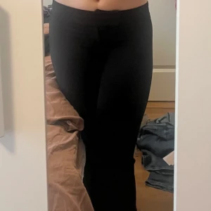 Svarta  kostymbyxor från Nelly - Svarta kostymbyxor från Nelly i storlek S med bootcut-snitt och låg midja. Mjukt och stretchigt material. Perfekta för en chill och snygg look.