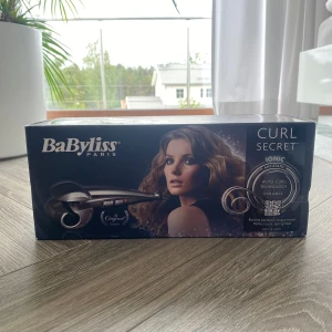 BaByliss Curl Secret Ionic locktång - BaByliss Curl Secret Ionic är en automatisk locktång i metalliclila med keramisk beläggning och jonisk teknologi. Den har auto-curl-funktion och antistatisk effekt för att skapa perfekta lockar snabbt och smidigt. Ergonomiskt handtag och lång sladd för enkel styling. Den är köpt för 1000 men säljer för 500