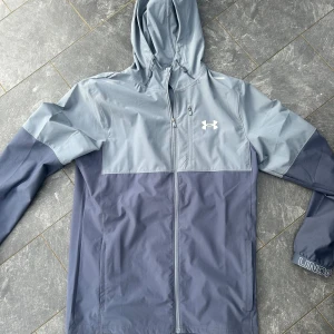 Blå vindjacka från Under Armour - Windbreaker från under armour i storlek M och passar perfekt 