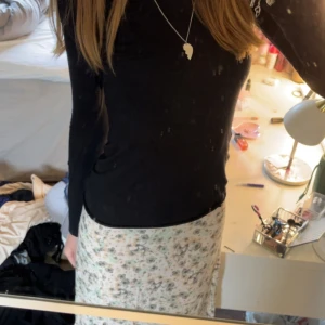 Blommig långkjol från H&M, strl 36 - Supersöt långkjol från H&M i storlek 36. Kjolen är vit med blommigt mönster i pastelliga toner av grönt, beige och grått. Den har en rak passform och en liten slits på sidan. Perfekt för vår och sommar när du vill ha en chill och romantisk vibe.