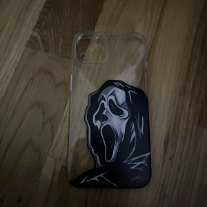 Genomskinligt mobilskal med Scream-motiv - Säljer ett genomskinligt mobilskal med ett stort svart och vitt Scream-ansikte på baksidan. Skalet är gjort i syntetmaterial och har öppning för kamera. Perfekt för dig som gillar skräck och vill sticka ut med din mobil!