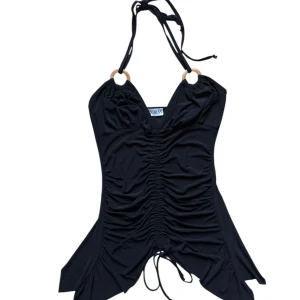 Vinrage Svart halterneck med snörning - Svart halterneck topp, kan ksk användas som kortare klänning. Kan justeras längd med snöret fram. Passar S-M