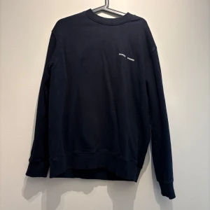 Svart sweatshirt från Samsøe Samsøe - En stilren svart sweatshirt från Samsøe Samsøe med diskret logga på bröstet. Tröjan har rund hals, långa ärmar och ribbade muddar. Perfekt för en clean och avslappnad look. Tillverkad i mjuk bomull för maximal komfort.