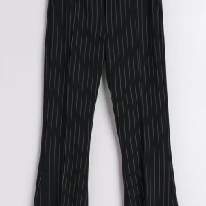 Svarta randiga kostymbyxor Gina Tricot XS - Svarta kostymbyxor från Gina Tricot i storlek XS med tunna vita ränder. Byxorna har en klassisk bootcut-modell, 