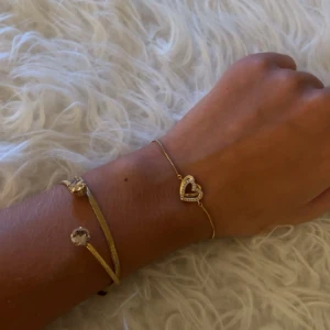hjärtarmband  - Säljer detta snygga guldarmband. Ett tunt kedjearmband med ett glittrigt hjärta i mitten. Perfekt för att ge din outfit lite extra bling och romantisk touch.