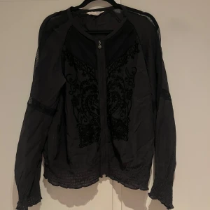 Odd Molly broderad overshirt med dragkedja - Svart overshirt/blus med snygga broderade detaljer framtill och meshpartier på axlar och ärmar. Storlek 2, motsvarar M 🖤
