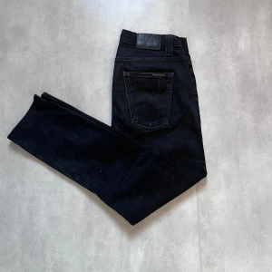 Svarta Nudie jeans  - Svarta jeans från Nudie Jeans Co – Ekologisk bomull ♻️ Tillverkade i ekologisk bomull 👖 Klassisk femficksdesign med raka ben 🧵 Snygga detaljer på bakfickan och stilren look 🧍‍♂️ Normal passform för en tidlös känsla    ✅ Storlek: 30/32  ✅ Skick: Mycket bra  💸 Originalpris: ca 1600 kr    Perfekta för dig som vill kombinera stil med hållbarhet. 📩 Skicka DM vid intresse!