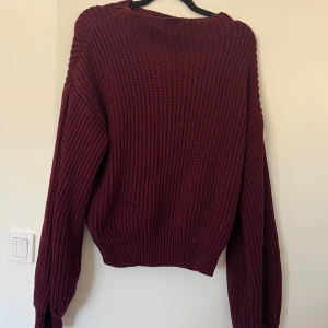 Vinröd stickad tröja med loose fit - Mysig vinröd stickad tröja med grov ribbstickning och avslappnad passform. 