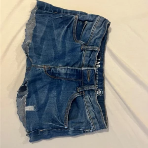 Blå jeansshorts från LAB Industries - Snygga blå jeansshorts från LAB Industries med kanter och slitningar. Klassisk femficksmodell med knapp och dragkedja framtill. Perfekta för varma dagar och en avslappnad stil.💖