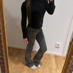 Grå bootcut jeans med slitning - Gråa jeans med bootcut passform och lätt slitning på ena benet. 