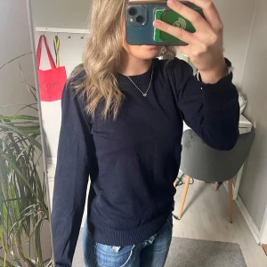 Mörkblå tröja från Saint Tropez - Säljer en enkel och stilren mörkblå tröja från Saint Tropez. Tröjan har rund halsringning, långa ärmar och ribbade muddar vid ärmslut och nederkant. Perfekt till jeans eller kjol för en clean look.