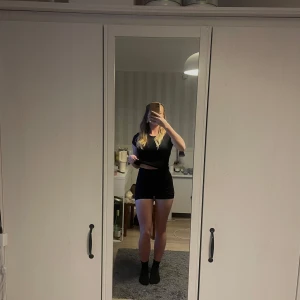 Svarta träningsshorts med hög midja - Svarta sträningsshorts med hög midja och tight passform. De har en diskret rynkdetalj bak för en snygg siluett. Perfekta för träning eller som basplagg till vardags. Mjukt och stretchigt material.