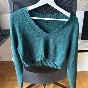Mörkgrön croppad stickad tröja från H&M - Säljer en mörkgrön croppad stickad tröja från H&M i superbra kvalité.