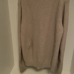 Beige stickad kofta med dragkedja - Mysig beige stickad kofta med lång ärm och hög krage. Koftan har dragkedja framtill och är perfekt för lager-på-lager under kyliga dagar. Enkel och stilren design som passar till det mesta. Priset kan diskuteras 