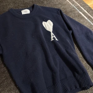 Mörkblå tröja Ami Paris - Säljer en ami Paris tröja i mörkblå, har taggarna kvar om du vill ha med dom. Perfekt för dig som gillar stilrena detaljer och klassisk design.