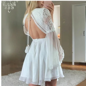 Helt ny! Vit klänning med spets och öppen rygg - Superfin, helt ny, vit klänning med v-ringning, spetsdetaljer och vida, transparenta ärmar. Klänningen har öppen rygg, perfekt för sommarens tillfällen eller student. Passar storlek XS-S | Köparen står för frakt 💗 