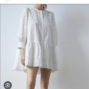 Vit broderad kortklänning från Zara - Superfin vit kortklänning från Zara med broderade detaljer och hålmönster. Klänningen har trekvartsärm med bred manschett och knappar, rund halsringning och en lös passform. Perfekt för sommarens alla tillfällen!