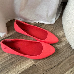 Rosa ballerinaskor med spetsig tå - Säljer ett par snygga rosa ballerinaskor med spetsig tå och platt sula. Skorna är i textilmaterial och har en enkel, stilren design som passar perfekt till vår och sommar.