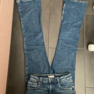Blå lågmidjade jeans från Gina Tricot - Snygga lågmidjade blå jeans från Gina Tricot i bootcut-modell. Jeansen har en något utsvängd passform nertill och är tillverkade i denim.