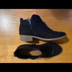 Svarta boots från Time and Tru - Säljer ett par svarta boots från Time and Tru med låg klack och dragkedja på sidan. Skorna är i mocka-liknande material och har en rund tå samt platt sula. Perfekta för dig som vill ha en stilren och enkel sko till vardags. Pris kan diskuteras 
