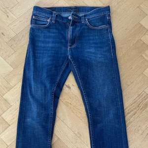 Mörkblå Nudie Jeans - Säljer ett par klassiska mörkblå jeans från Nudie det är en snygg blå färg som passar för allt skicket är 8/10. Skriv för frågor eller funderingar.