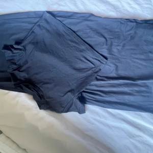 Mörkgrå t-shirt och kjol, ett set - En basic mörkgrå set med rund hals och korta ärmar. Perfekt till jeans eller shorts för en enkel och stilren look. T-shirten har en klassisk passform och är tillverkad i mjukt material.