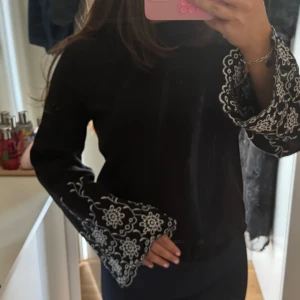 svart tröja  - super vacker svart tröja med stora ärmar och blom detaljer!!! storlek M/38!!