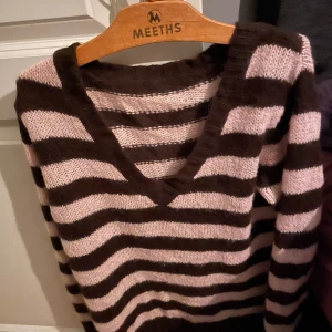 Brun och beige randig stickad tröja med v-ringning - Rosa och brun stickad tröja. Den har blivit lite nopprig men annars är den i bra skick